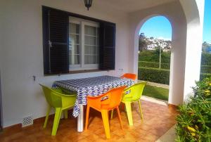 a dining room table with colorful chairs around it at Son Bou Bonito y renovado Apartamento in Alaior