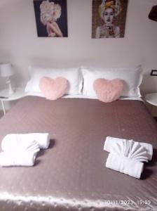 ein Bett mit zwei herzförmigen Kissen darauf in der Unterkunft La dimora di Sandy in Viterbo