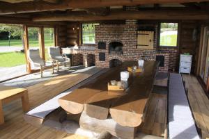 a patio with a table and a brick fireplace at Mäeküla Järve Palkmaja in Viljandi