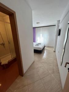 ein Zimmer mit einem Bett in der Mitte eines Zimmers in der Unterkunft Apartmani Jukanovic in Baška Voda
