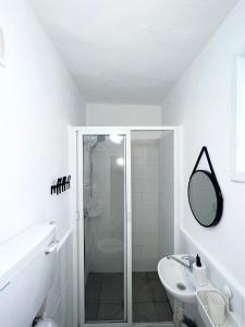 a white bathroom with a shower and a sink at Carmel Market center apartments TLV in Tel Aviv