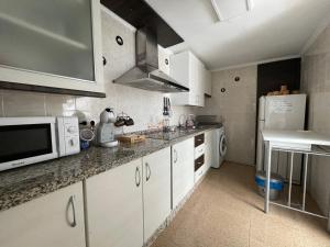 a kitchen with white cabinets and a microwave at Casa LuLa in Villafranca de Córdoba