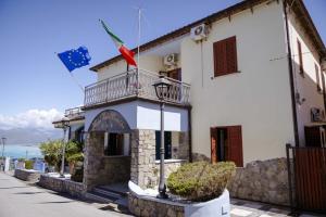a building with a balcony and flags on it at Hotel Villa Principe in San Nicola Arcella