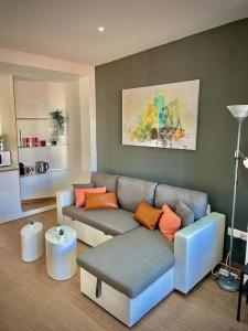a living room with a gray couch and orange pillows at Elegant Rooftop by F2 Rental Home in Valencia