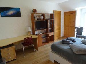 Schlafzimmer mit einem Bett und einem Schreibtisch mit einem TV in der Unterkunft Cafecouet'Breizh in Guipry-Messac