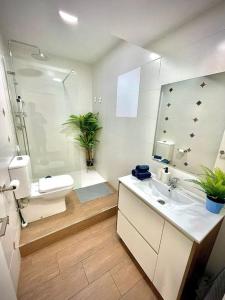 a bathroom with a sink and a toilet and a mirror at Elegant Rooftop by F2 Rental Home in Valencia