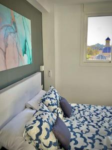 a bedroom with a bed with pillows and a window at Elegant Rooftop by F2 Rental Home in Valencia +20 photos