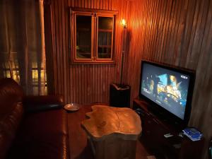 a living room with a couch and a flat screen tv at Appartement Chalet type f3 in Kribi