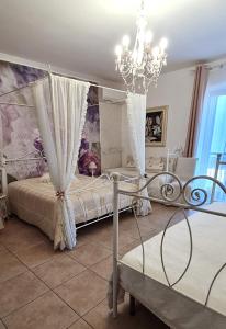 een slaapkamer met 2 bedden en een kroonluchter bij Poesia in Lesina