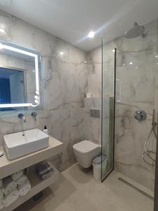 a bathroom with a toilet and a sink and a shower at Armeno Studios in Limenaria +41 photos