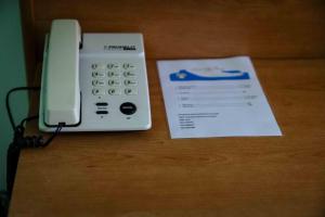 a phone sitting on a table next to a piece of paper at Hotel Villa Principe in San Nicola Arcella