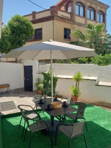 a table and chairs with an umbrella in a yard at POWER HOME in Granada