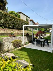 een paviljoen met een tafel en stoelen in een tuin bij Il Piccolo Borgo in Valdobbiadene