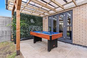 a ping pong table sitting under a pergola at Luxury City Centre 5 Bed House with FREE parking in Birmingham