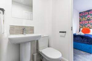 a white bathroom with a toilet and a sink at Luxury City Centre 5 Bed House with FREE parking in Birmingham +53 photos