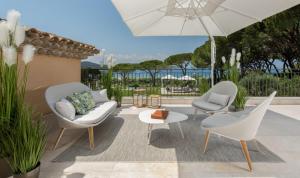 a patio with two chairs and an umbrella at Steiner in Saint-Tropez