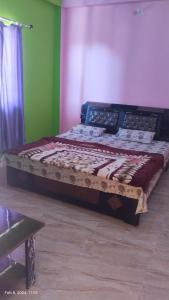 a bed with a wooden frame in a room at Parvati Home Stay in Bhowāli
