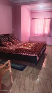 a bedroom with a large bed in a room at Parvati Home Stay in Bhowāli