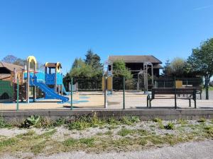 a playground with a slide in a park at Bel appartement entre lac et montagne in Thollon