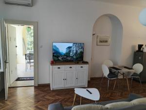 a living room with a tv and a table and chairs at apartman Marko in Lovran
