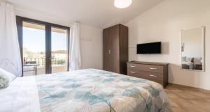 a bedroom with a bed and a dresser and a television at CASA PIUMA Castiadas - casa vacanza Costa Rei - Villasimius in Olìa Speciosa