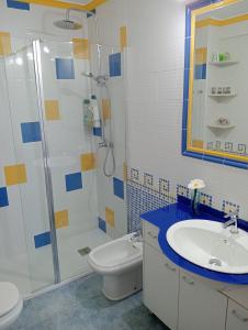 y baño con aseo, lavabo y ducha. en Piso primera línea de playa en Málaga