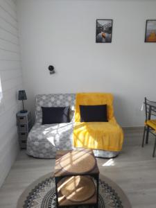 una camera con un letto con una coperta gialla e una sedia di Studio 4 pers. bord de plage a La Guérinière