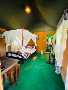 a room with a bed and a green floor at Animal View Point Yala in Tissamaharama