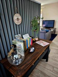 een houten tafel met boeken en een klok aan een muur bij Croí Beag Luxury Studio in Dundalk