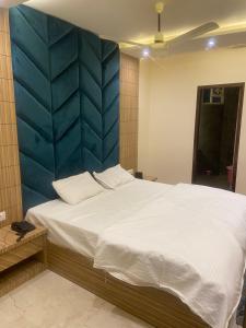 a bedroom with a large bed with a blue wall at HOTEL GANDHI in Alwar