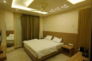 1 dormitorio con 1 cama grande y espejo en HOTEL GANDHI en Alwar