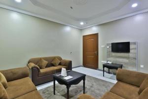 een woonkamer met 2 banken en een flatscreen-tv bij look house in Amman