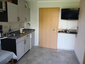 une petite cuisine avec un évier et une porte. dans l'établissement Haus Stefanie, à Heringsdorf 3 autres photos