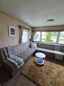 a living room with a couch and a table at Caravan Turnberry 2 in Port Seton