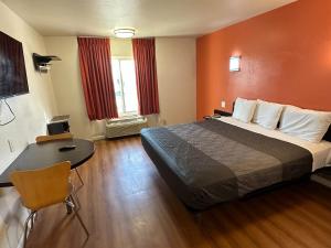 a hotel room with a bed and a table at Beachside Inn in Anaheim