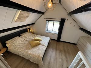 a small bedroom with a bed in a attic at Snijders cottage in Noordwijkerhout