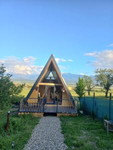 a small house with a porch and a fence at Aframe Bradu in Bradu