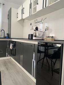 a kitchen with black and white cabinets and a table at Fabri's Studio Brasov in Braşov