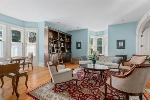 una sala de estar con paredes azules, mesas y sillas en Manoir Sweetsburg, en Cowansville