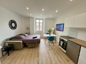 a bedroom with a bed and a table and a kitchen at Masha *CLIM* proche hospital in La Tronche