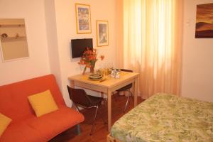 Camera con scrivania, letto, tavolo e sedia. di Nice Apartment in Taormina a Taormina