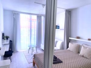 1 dormitorio con cama, mesa y ventana en Los Cristianos, en Los Cristianos