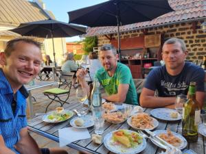 tres hombres sentados en una mesa con platos de comida en Värdshuset & Brukshotellet i Lövstabruk, en Lövstabruk