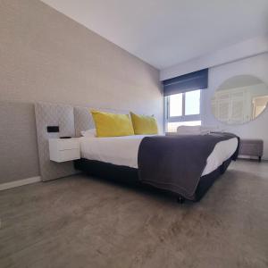 ヴィラモウラにあるQuinta Do Romãoのベッドルーム1室(大型ベッド1台、黄色い枕付)