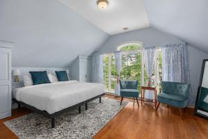 CowansvilleにあるManoir Sweetsburgのベッドルーム1室(ベッド1台、青い椅子2脚付)