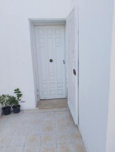 a hallway with a white door and a tile floor at Dar ettawfik in Tataouine