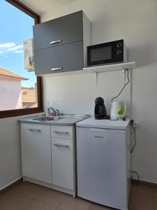 una cucina bianca con lavandino e forno a microonde di Elena Guest House a Sozopol