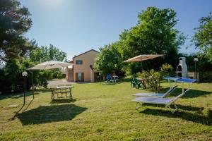 un grupo de mesas de picnic y sombrillas en un patio en Agriturismo Conero, en Ancona