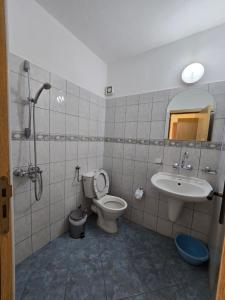 y baño con aseo y lavamanos. en Elena Guest House, en Sozopol