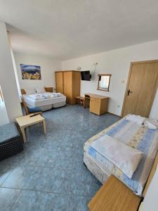 una camera d'albergo con due letti e una televisione di Elena Guest House a Sozopol